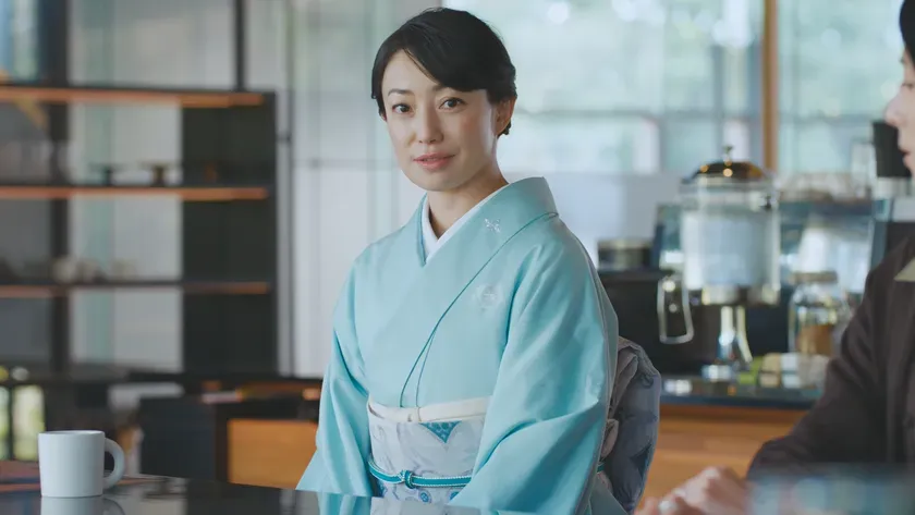 カフェで着物を着た女性がカメラを見て微笑んでいる様子